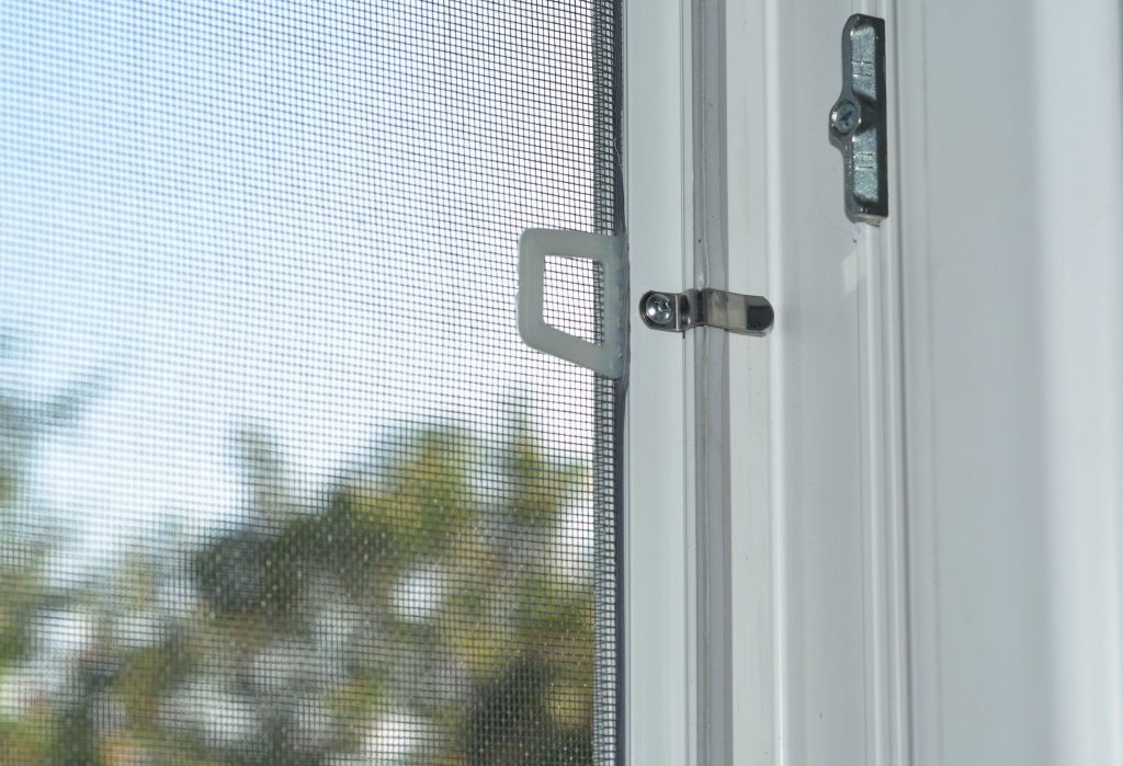 Close-up on mosquito wire screen installation on window to protect from flies, mosquitos and other insects.