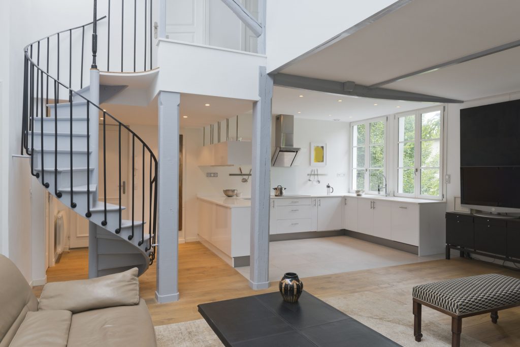 Weitwinkel des Wohnraums und der Küche mit Wendeltreppe.